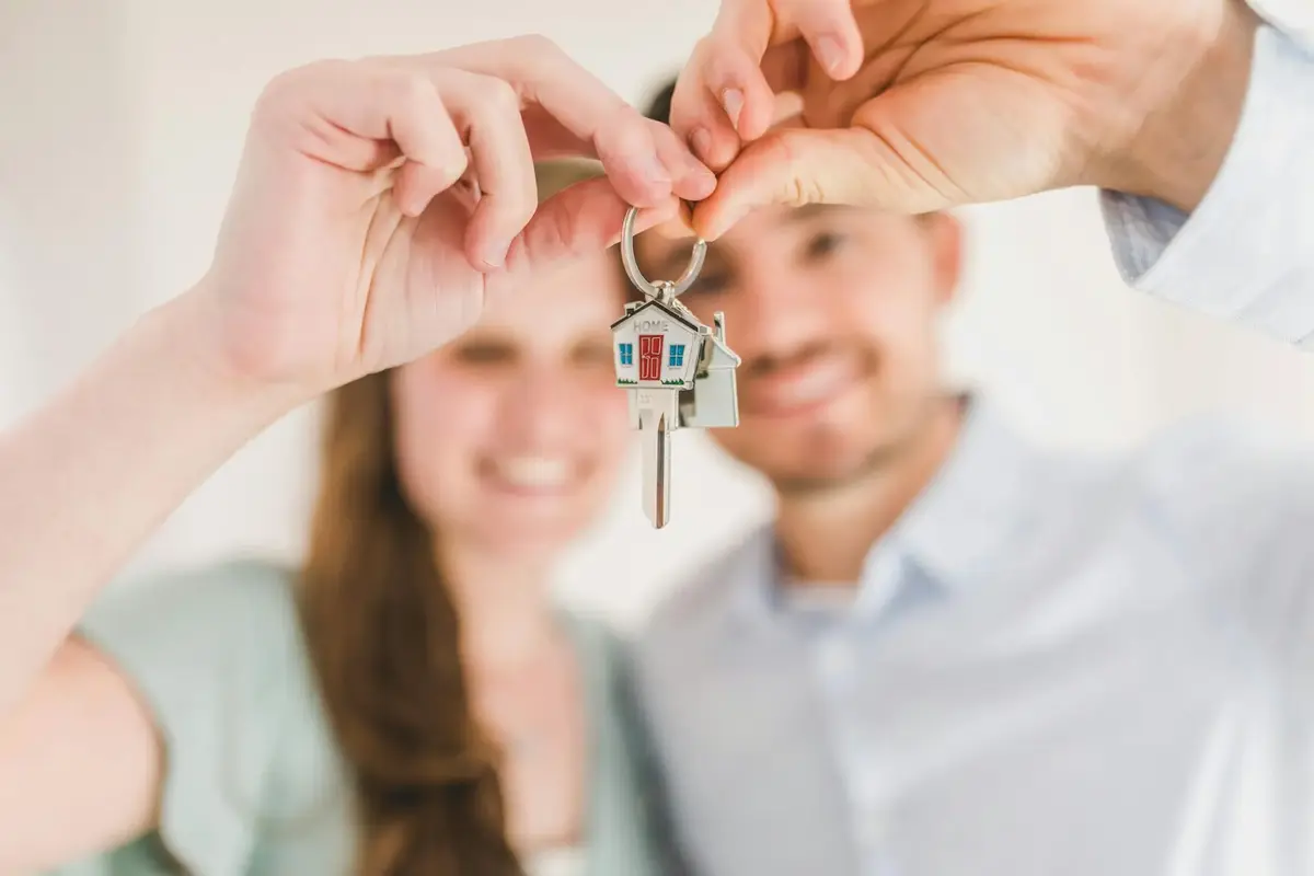 Couple holding house keys while planning how much house they can afford