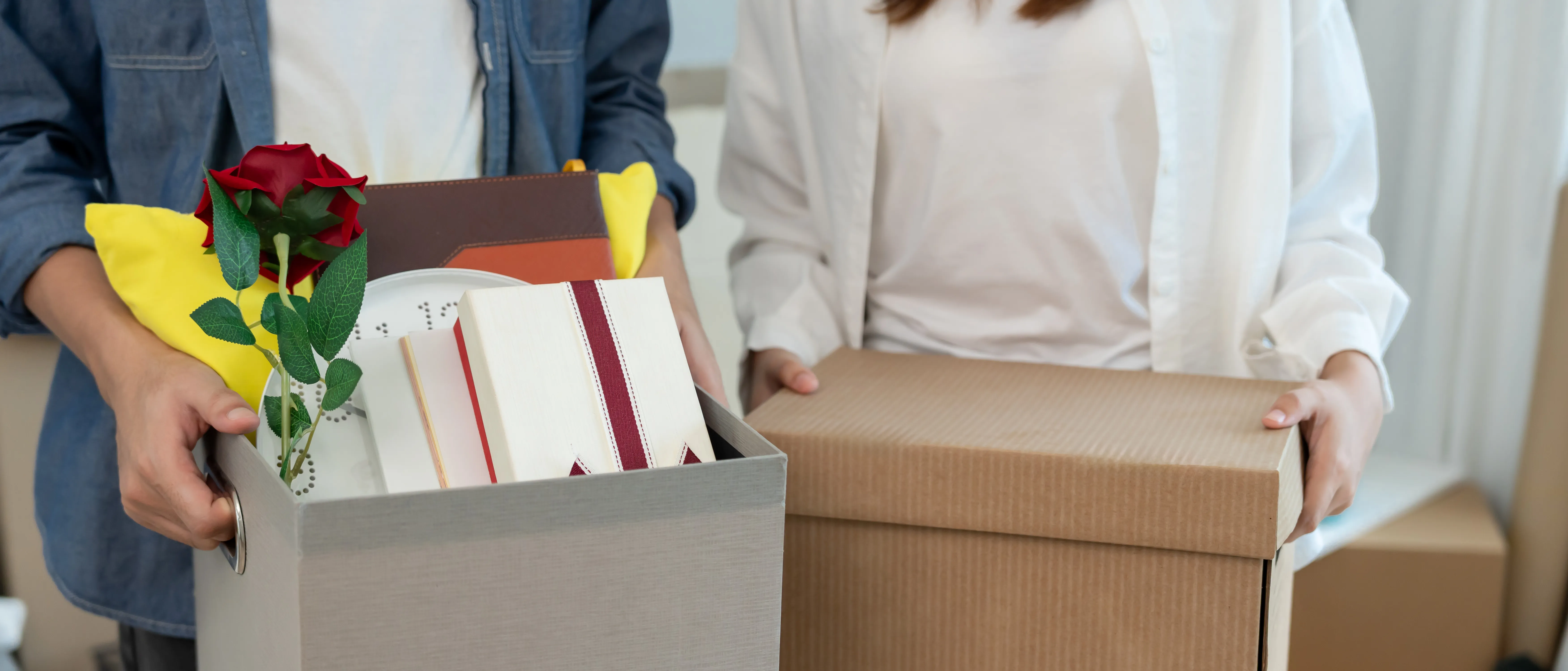 Couple carrying moving boxes